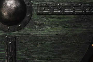 Old green Viking shield with metal umbo texture background.