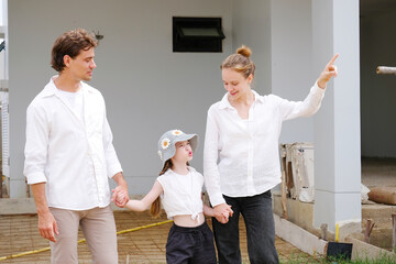 Father, mother, and child standing with bright smiles — a family concept.