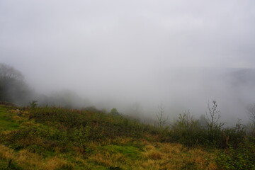 Misty valley landscape featuring autumn foliage in The Peak District, England.