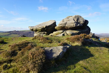 Scenic wind sculpted gritstone rocks and heather moorland in The Peak District, England.