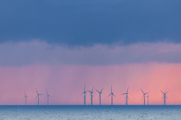 Stunning sunset over the sea near Denmark, captured from a cruise ship. Wind turbines silhouette...