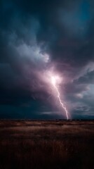 Dramatic lightning bolt striking over a remote field at night