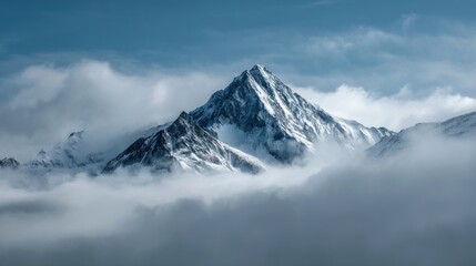 Obraz premium Majestic snow capped mountain peak rising above clouds