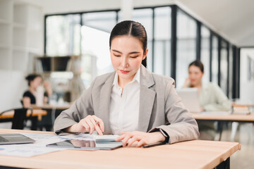 Confident businesswoman working tablet and paperwork modern office focused and productive atmosphere