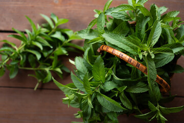 Bountiful harvest of fresh mint leaves gathered in a rustic basket on a wooden surface