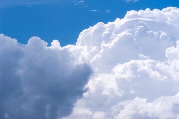 Piękne, bogato teksturowane chmury deszczowe na tle błękitnego nieba wiosennego. Duże chmury cumulonimbus dominują na żywym, błękitnym niebie. Wznoszące się formacje są gęste i falujące.