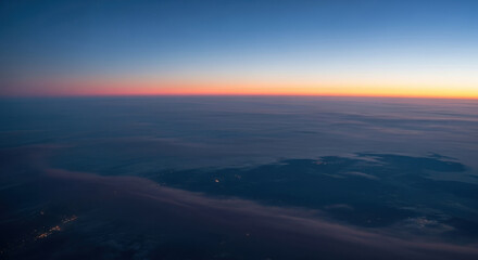 Fototapeta premium An aerial view of a sunset with clouds and a gradient sky from blue to orange and pink color palette