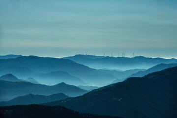 Misty layers of blue-hued Korean mountains at dawn, evoking a serene and mystical atmosphere