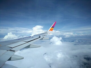 Commercial Airplane Wing Above Dense Cloud Layer – Sky Travel View from Aircraft Window on Sunny...