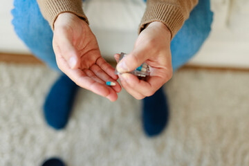 Caucasian Male Taking Medicine While Sitting Comfortably in a Warm Living Room Environment
