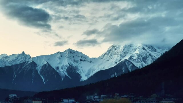 Snow - capped mountains gradually illuminated by sunlight in the early morning, time - lapse photography