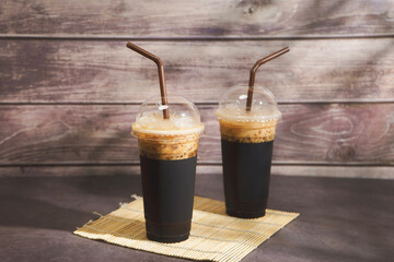Two glasses of iced coffee with milk on an old wooden table