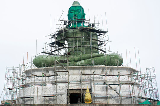 Renovate building sculpture carving Green buddha statue on ancient ordination hall and antique ubosot for travelers thai people join donate in Wat Khao Phra In Buddhist Temple in Surat Thani, Thailand