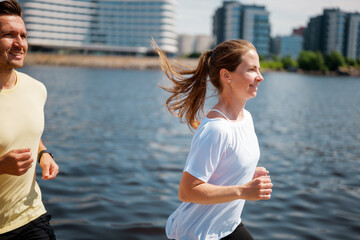 Jogging along the waterfront, two friends enjoy a sunny day in a bustling urban environment surrounded by modern architecture