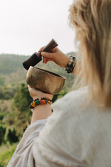 Close-up of female hands holding sound healing instruments. Tools for therapy, inner balance, and...