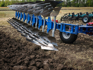 Large industrial plow for tilling soil in the field.