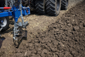 Close-up of a plowed field. Work of agricultural equipment.