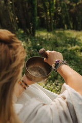Close-up of female hands holding sound healing instruments. Tools for therapy, inner balance, and...