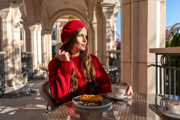 Woman Beret Coffee: Girl enjoys cafe latte and pastry on sunny terrace with arcade backdrop.