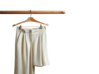  Cream-Colored Folded Trousers on Wooden Hanger Against Green Background on white background 