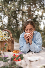 Picnic Flowers Coffee: Woman enjoys tea with picnic basket in nature daytime for relaxation.