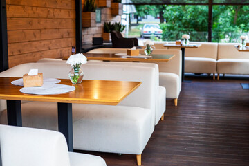 cozy stylish tables with white chrysanthemums in the restaurant outside