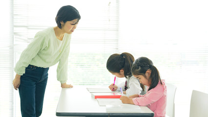 教室で子供たちに授業する女性教師