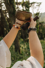 Close-up of female hands holding sound healing instruments. Tools for therapy, inner balance, and...