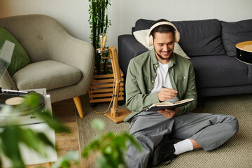 Creative young man enjoying quiet moments while writing in a cozy home setting with music