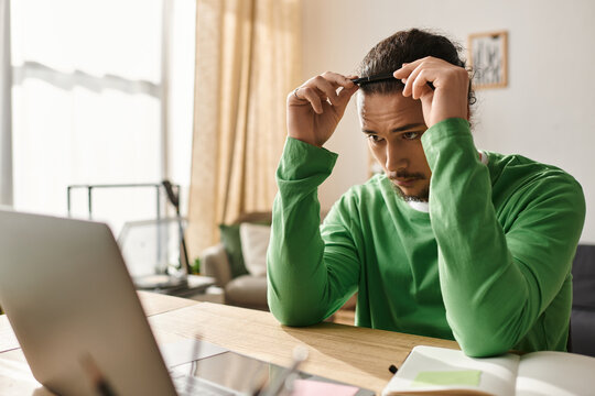 Young handsome man focused on work at home during afternoon hours while adjusting his hair - Powered by Adobe