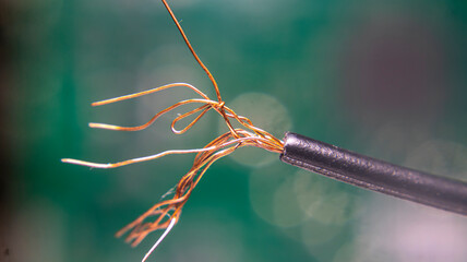 Close-up of copper electrical wire strands, showing detailed texture and twisted filaments. Ideal...