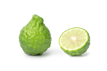 whole and halved fresh bergamot fruit, showcasing its rough green skin and interior texture, placed...