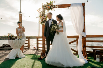wedding ceremony on a high pier near the river