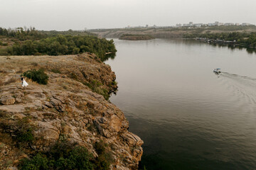 young couple a guy and a girl are walking in the green hills