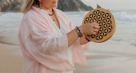Close-up of female hands holding sound healing instruments. Tools for therapy, inner balance, and...