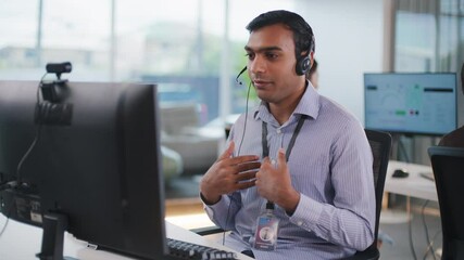 Professional Indian businessman offering remote CRM support in a tech-driven, diverse workplace. Consulting clients online with communication tools, headset, and call center software. - Powered by Adobe