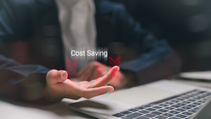 Businessman holding virtual cost-saving icon with red downward arrows. Concept of fast expense...