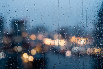 Rain-covered glass window with dense droplets and city lights in cool evening tones Generative AI