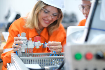 Female engineers checking or maintenance electronic in AI Robot, robot arm in the manufacturing...
