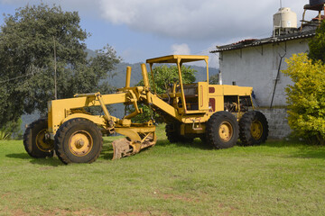 Motoniveladora amarilla en campo en el pueblo mágico de Zacatlán, Puebla, México