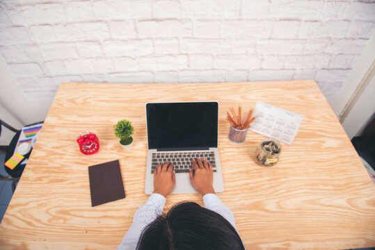 Asian Female freelance using laptop at home office desk. Woman reading financial graph chart Planning analyzing marketing data. Asian female people working office firm with business stuff, coffee cup