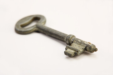 Old rusty door key isolated on white.
