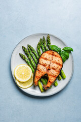 Grilled salmon fish steak over grilled asparagus