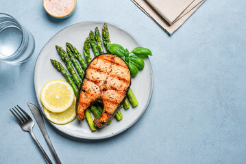 Grilled salmon fish steak over grilled asparagus