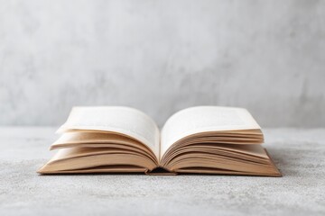 old hardback book laying open on clean concrete surface