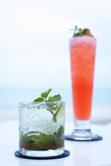 Refreshing cocktails served on a table with a beach view, perfect for summer relaxation and vibrant...