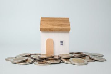 Wooden house model on money coins stack. Mortgage from the bank for a property investment.