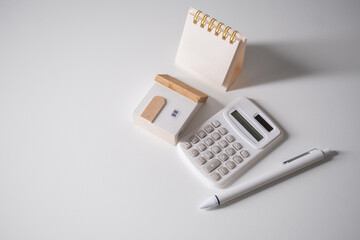 Home loan interest payment appointment. Calendar, house model, calculator and pen on the white...