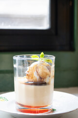 A delectable dessert featuring creamy layers and a topping of rich ice cream, served in an elegant...
