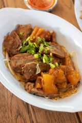 A delicious serving of tender meat with vegetables, garnished with green onions, showcasing vibrant flavors and textures.